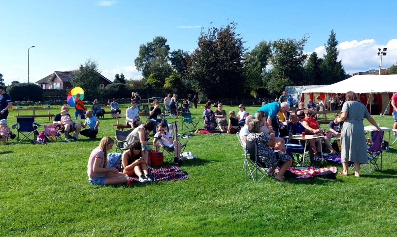 A community event on the sports field with a marquee and families